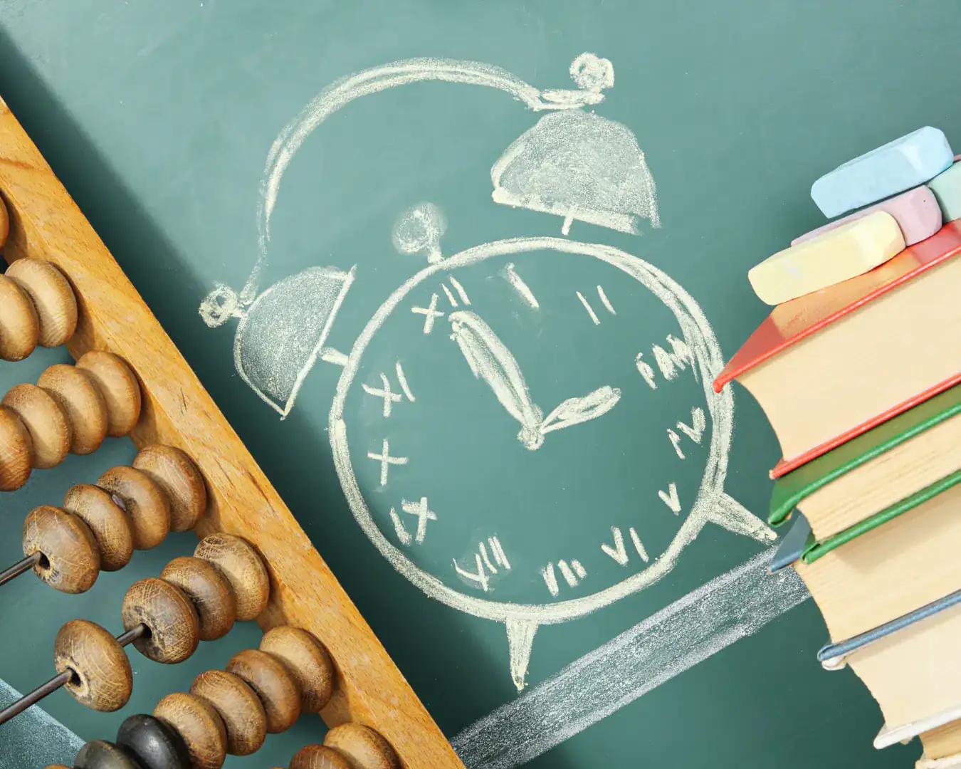 Green chalkboard with a chalk-drawn alarm clock, abacus, books, and colored chalk—education and scheduling theme