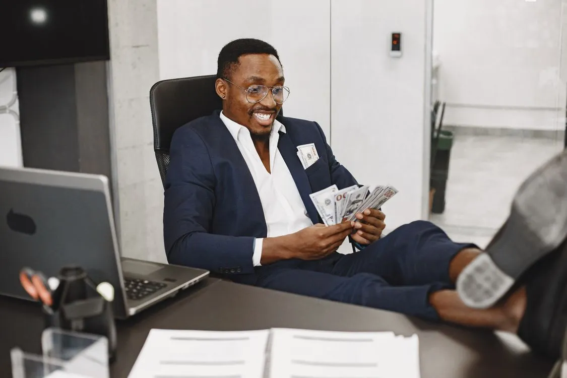 Businessman counting cash in an office, representing business capital sources