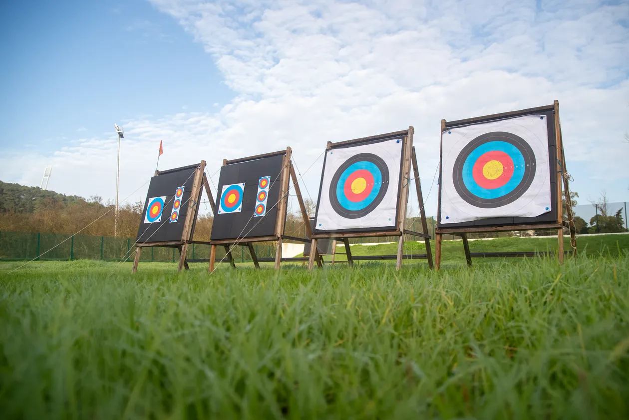 Row of colorful archery target boards standing on grass under a blue sky