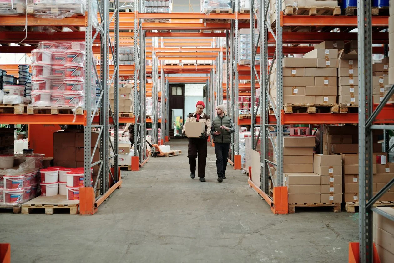Workers walking along aisle in a warehouse — inventory financing for manufacturing and distribution